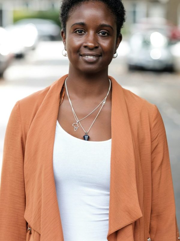 Black woman looking at camera in the street.